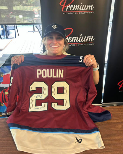 MPP holding a maroon hockey jersey with 'Poulin' and number '29' in front of a 'Premium Autographs & Collectibles' sign.